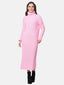 Eine Person in einem langen, rosa Rollkragenpulloverkleid, perfekt für jede Herbst- und Wintergarderobe, und schwarzen Stiefeletten steht vor einem schlichten weißen Hintergrund. Das gerippte Strickkleid harmoniert mit ihren langen, dunklen Haaren, während sie sanft lächelt.