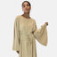 Eine Person posiert anmutig vor einem hellen Hintergrund. Sie trägt Elaras lange beige Abaya mit weiten Ärmeln und einer taillierten Taille mit Schnürung. Ihr Haar ist zurückgebunden, und als Accessoire tragen sie Creolen, die eleganten Komfort ausstrahlen.