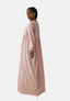 Eine Person präsentiert vor weißem Hintergrund ein fließendes, langärmeliges rosa Damen Abaya Maxikleid von Elara mit orientalischem Flair. Ihr langes Haar ist zurückgebunden und sie trägt Ohrringe und Armbänder.