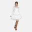Eine Person modelt in einem knielangen, weißen Spitzenkleid von Elara mit hohem Kragen und langen Ärmeln, elegant kombiniert mit schwarzen Sandalen mit hohen Absätzen vor einem schlichten weißen Hintergrund.