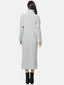 Rückansicht einer Person, die ein langes, hellgraues Strickkleid mit Rollkragen trägt, das elegant bis zu den Knöcheln reicht. Kombiniert mit schwarzen Stiefeln mit Absatz ist dieses Ensemble vor einem schlichten weißen Hintergrund perfekt für Ihre Herbst- und Wintergarderobe.