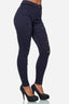 Eine Person, die hoch taillierte Elara-Jeans mit dunkelblauen, zerrissenen Röhrenjeans und schwarze High Heels trägt, steht vor einem schlichten weißen Hintergrund.