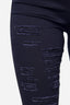 Eine Nahaufnahme des Oberschenkels einer Person zeigt schwarze Elara-Jeans mit mehreren horizontalen Rissen und ausgefransten Kanten vor einem schlichten weißen Hintergrund.