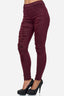 Eine Person in zerrissenen burgunderfarbenen Röhrenjeans von Elara und schwarzen High Heels, von der Taille abwärts vor einem weißen Hintergrund.