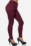 Eine Frau in zerrissenen Röhrenjeans „Elara“ in Burgunderrot mit Used-Look vorne und schwarzen High Heels steht vor einem schlichten weißen Hintergrund.
