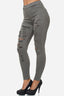 Vor einem schlichten weißen Hintergrund steht jemand und trägt hoch taillierte olivgrüne Röhrenjeans von Elara mit Rissen vorne und schwarze Stöckelschuhe.