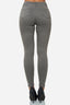 Eine Person, die graue Röhrenjeans von Elara und schwarze Stöckelschuhe trägt, von hinten vor einem schlichten weißen Hintergrund gezeigt.