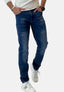 Eine Person in Elara-Bluejeans, einem weißen Langarmhemd, einer schwarzen Uhr und Elara-weißen Sneakers mit schwarzen Streifen steht mit den Händen in den Taschen vor einem schlichten Hintergrund.