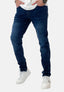 Eine Person, die dunkelblaue Slim-Fit-Jeans von Elara, ein weißes Hemd und weiße Turnschuhe trägt, steht mit den Händen in den Taschen vor einem schlichten weißen Hintergrund.