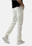 Eine Person trägt Elara weiße Jeans im Waschlook mit bequemer Passform, ein schwarzes Shirt und weiße Sneakers mit schwarzen Streifen und wird von hinten und seitlich beim Gehen vor weißem Hintergrund gezeigt.