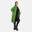 Eine Frau präsentiert eine lange, übergroße Strickjacke mit Taschen von Elara, ein schwarzes Hemd, eine schwarze Hose und Stiefel vor einem schlichten weißen Hintergrund für einen lässigen Look und maximalen Komfort.