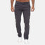 Ein Mann in einer dunkelgrauen Elara Slim Fit Chinohose und weißen Sneakers steht vor einem schlichten weißen Hintergrund und verbindet klassischen Stil mit modernem Komfort. Sein Oberkörper ist nicht vollständig sichtbar.