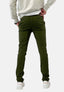 Eine Person steht mit dem Rücken zur Wand und trägt eine olivgrüne Elara Slim Fit Chino-Hose für optimalen Tragekomfort, ein helles Sweatshirt und weiße Turnschuhe vor einem schlichten weißen Hintergrund.